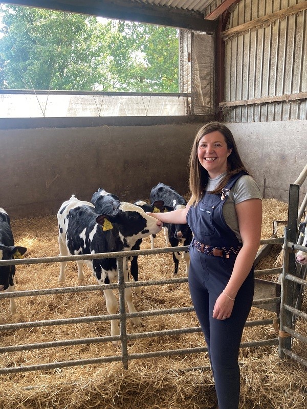Helen Holliday standing in a barn with calves.